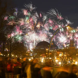 Buntes Feuerwerk ist am Himmel über der Stadt um Mitternacht zu sehen.