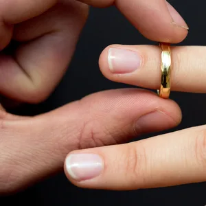 Ein Ring wird an der Finger einer Frau gesteckt.