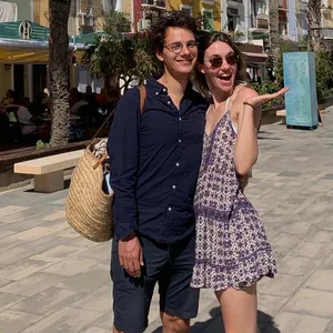 Ein junges Paar steht Arm in Arm auf der Promenade