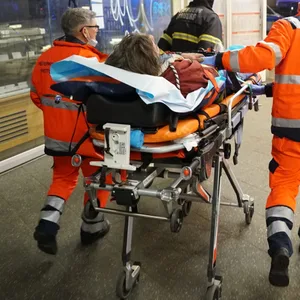 Rettungskräfte bringen den Mann zum Krankenwagen.