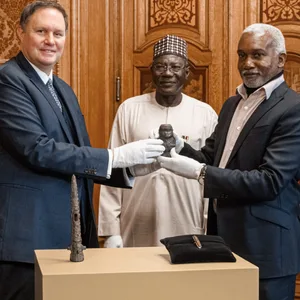 Carsten Brosda übergibt dem nigerianischen Botschafter Yusuf Madame Tuggur eine kleine Statue.