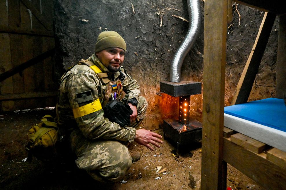 Ukrainischer Soldat wärmt sich an der Front