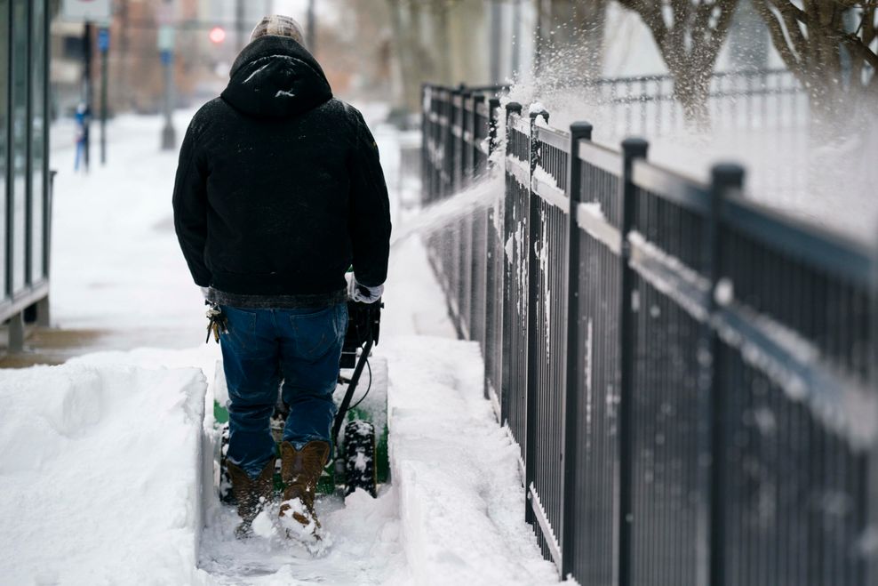 In Columbus, Ohio räumt ein Mann Schnee von der Straße.