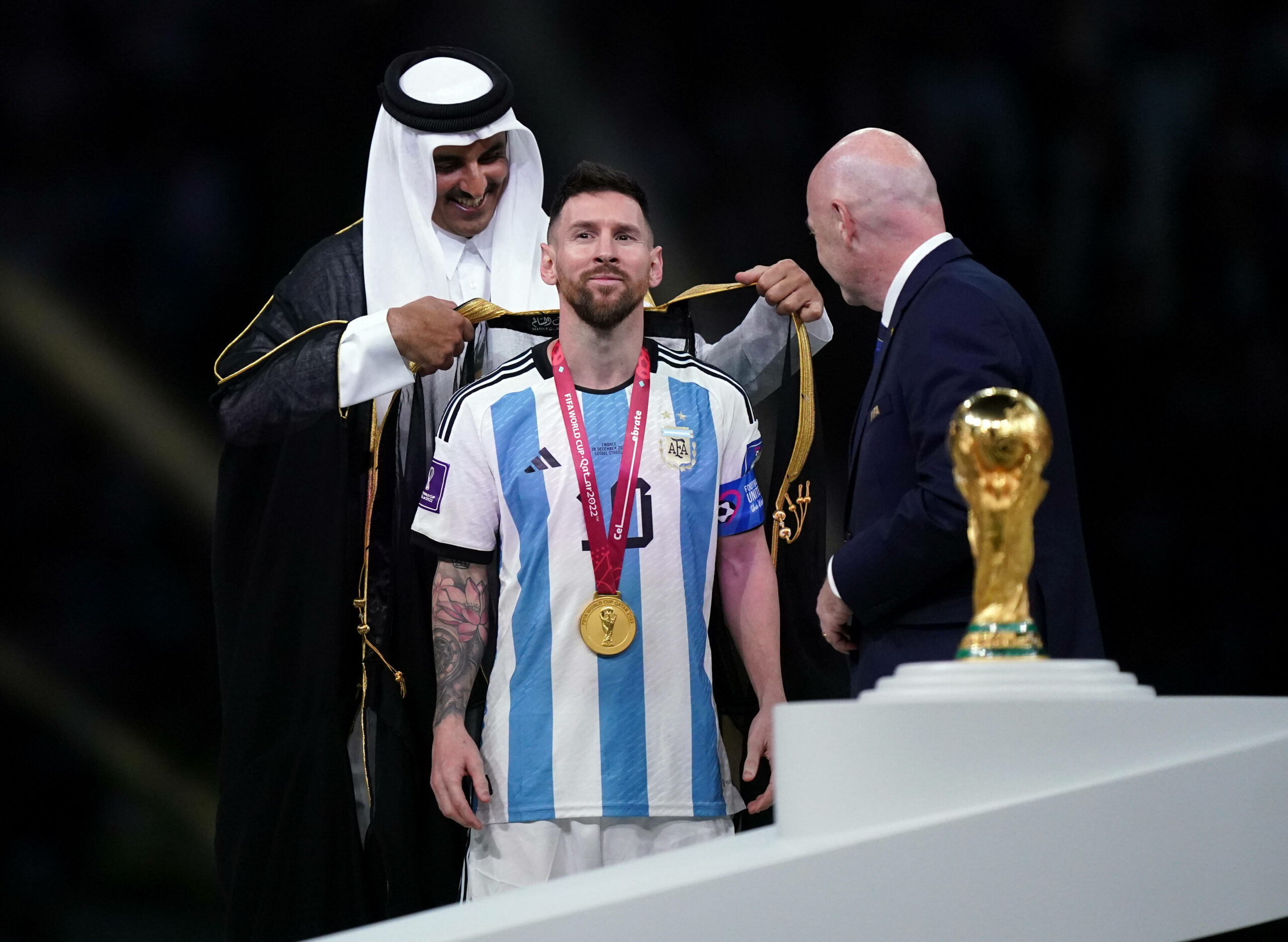 Lionel Messi (MItte) erhält kurz vor der Pokal-Übergabe ein arabisches Gewand.