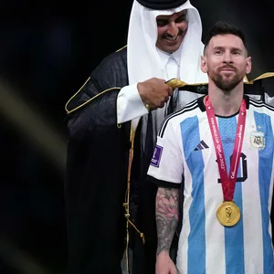Lionel Messi (MItte) erhält kurz vor der Pokal-Übergabe ein arabisches Gewand.