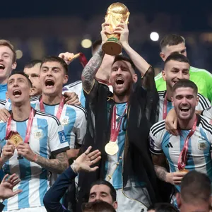 Lionel Messi reckt den WM-Pokal in die Höhe.