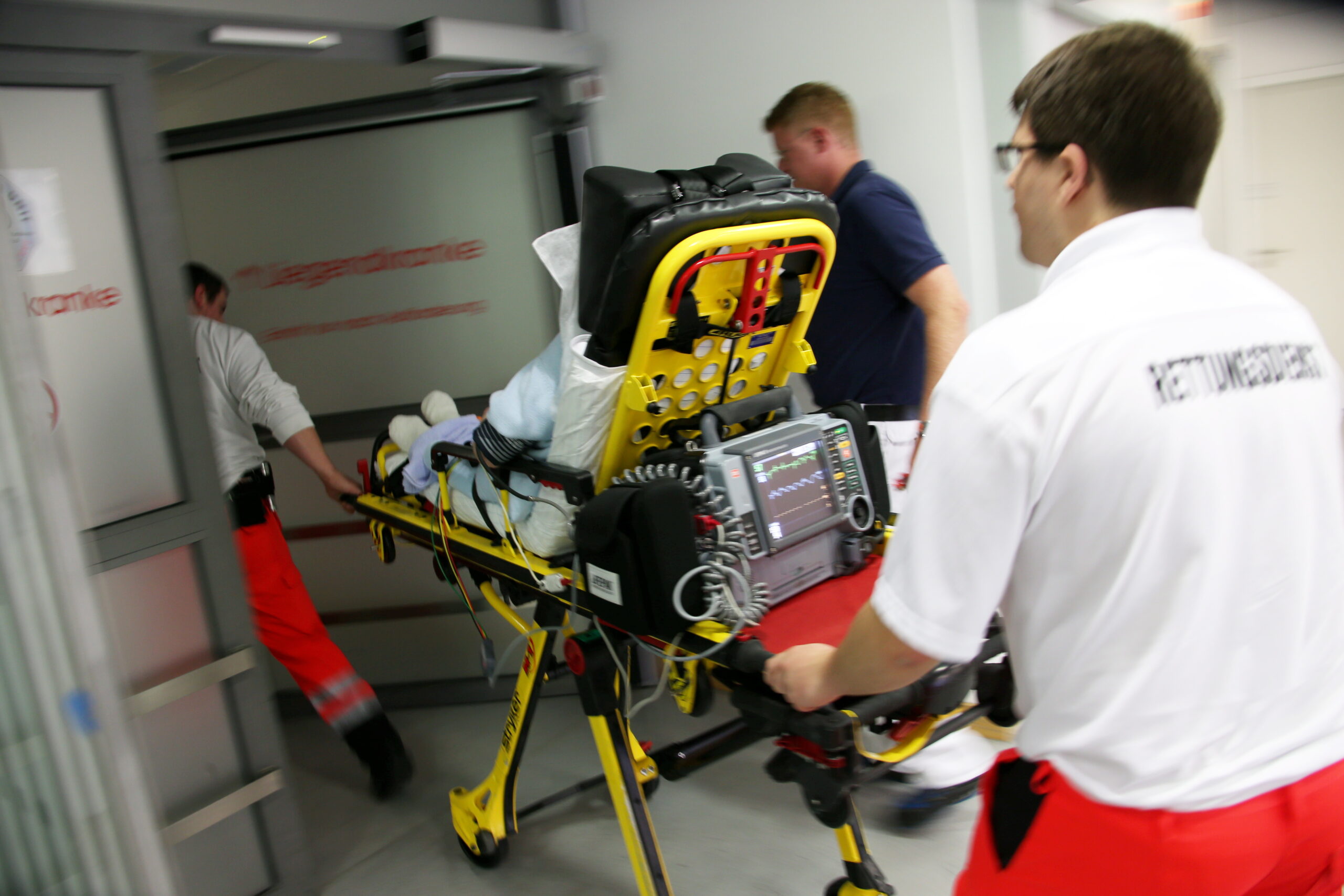 Rettungssanitäter liefern eine Notfallpatientin in ein Krankenhaus ein (Symbolbild).