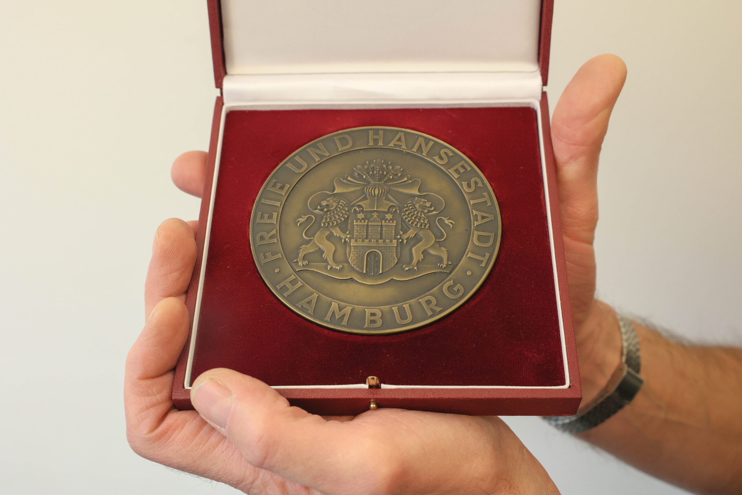 Die massive Bronze-Medaille für „treue Arbeit im Dienste des Volkes“ einem roten Etui mit dem Großen Hamburger Staatswappen
