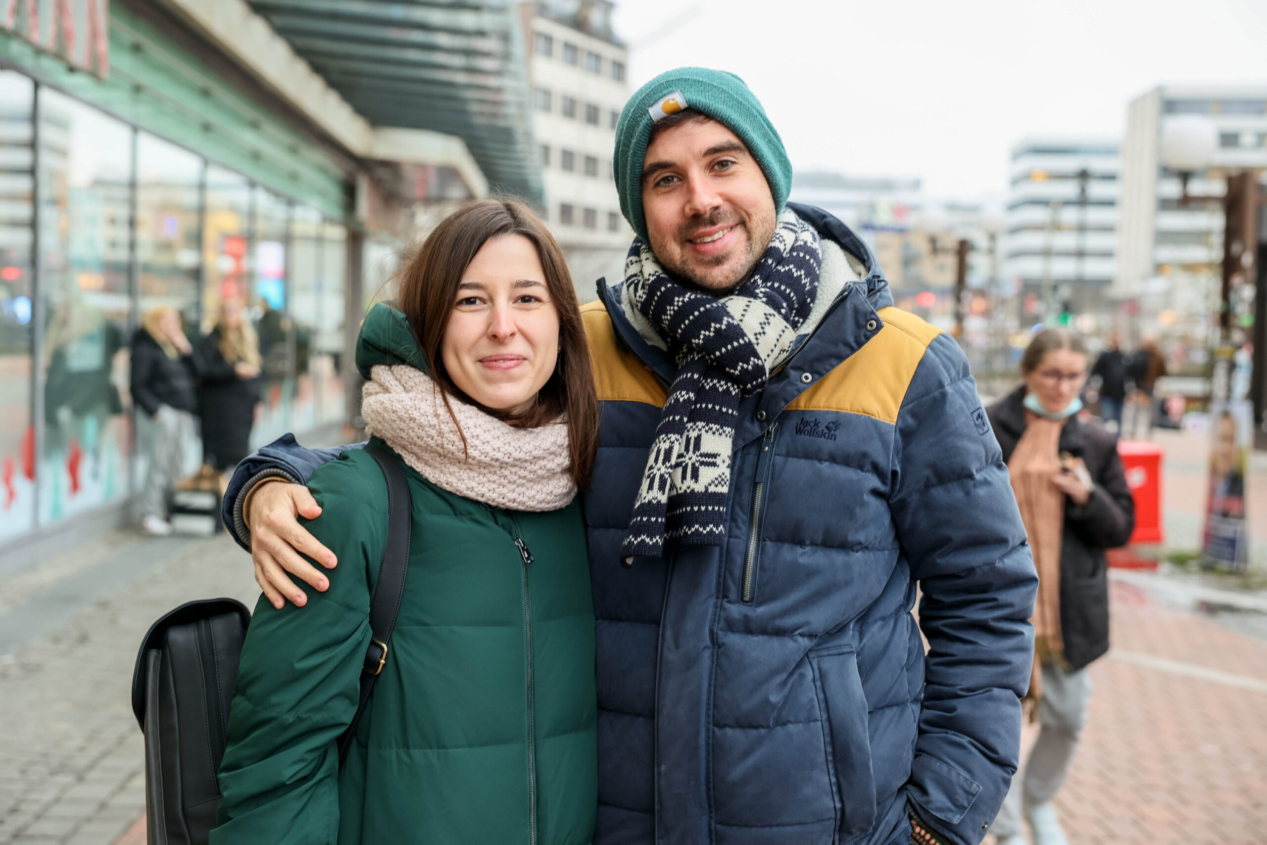 Ein junges Paar steht Arm in Arm vor dem Altonaer Bahnhof