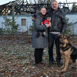 Bea Farid (49) und Klaus Thiering (62) stehen mit ihren Hunden „Herrn Lehmann“ und „Pummelfee“ vor ihrem abgebrannten Haus.