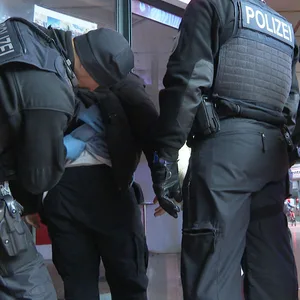 Polizisten kontrollieren am Hamburger Hauptbahnhof einen Mann.