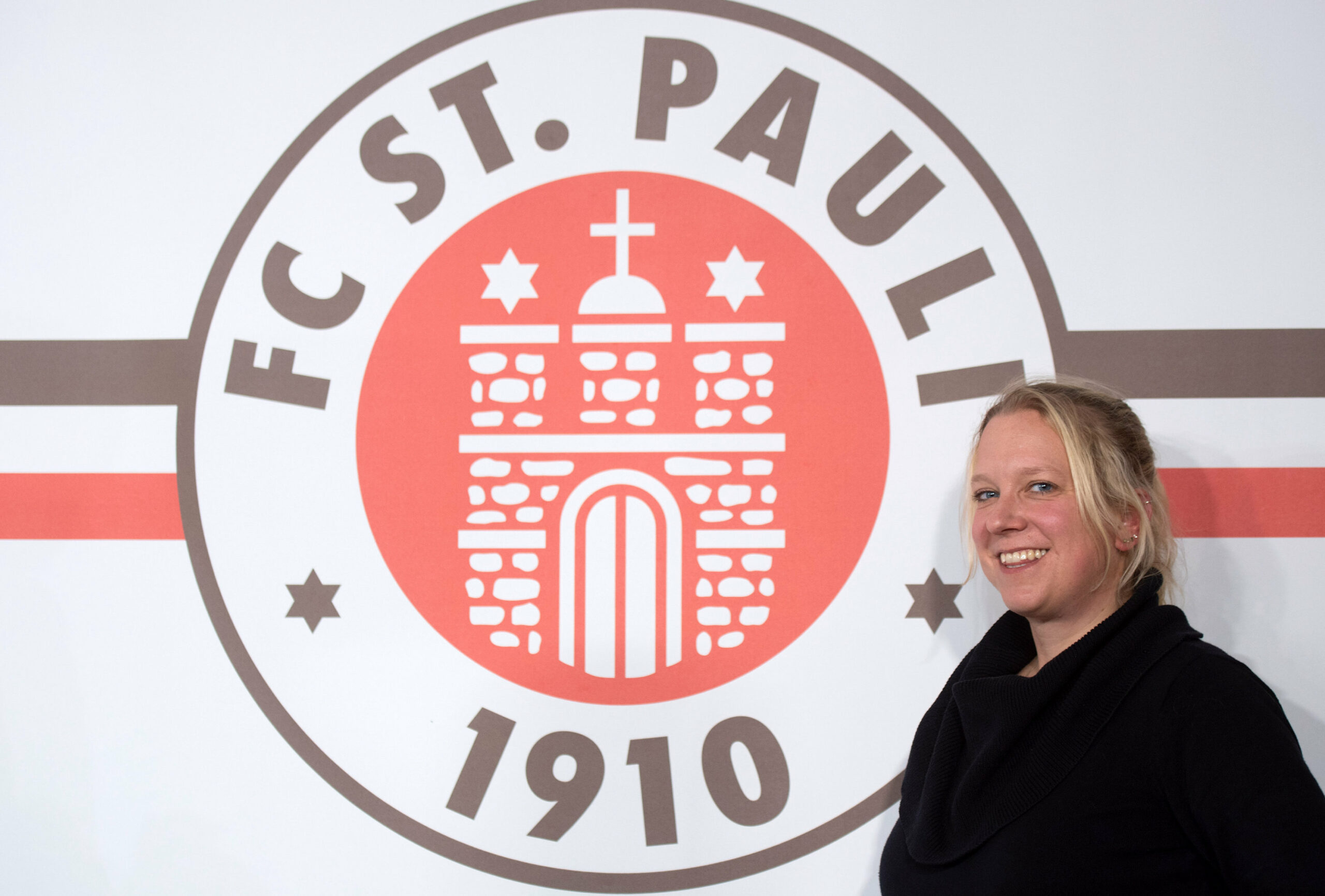 St. Paulis Aufsichtsratvorsitzende Sandra Schwedler vor dem Logo