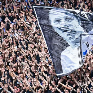 HSV-Fans beim Gedenken an Uwe Seeler mit einer Fahne