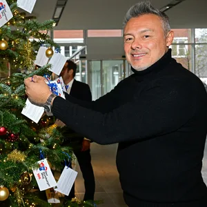 Rodolfo Esteban Cardoso schmückt einen Weihnachtsbaum.