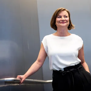 Kathrin Baumstark steht lächelnd in einem Fahrstuhl