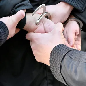 Polizisten legen einem Mann Handschellen an (Symbolfoto).