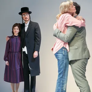 Vorne umarmen sich Mann und Frau, hinten stehen Mann und Frau und sehen zu