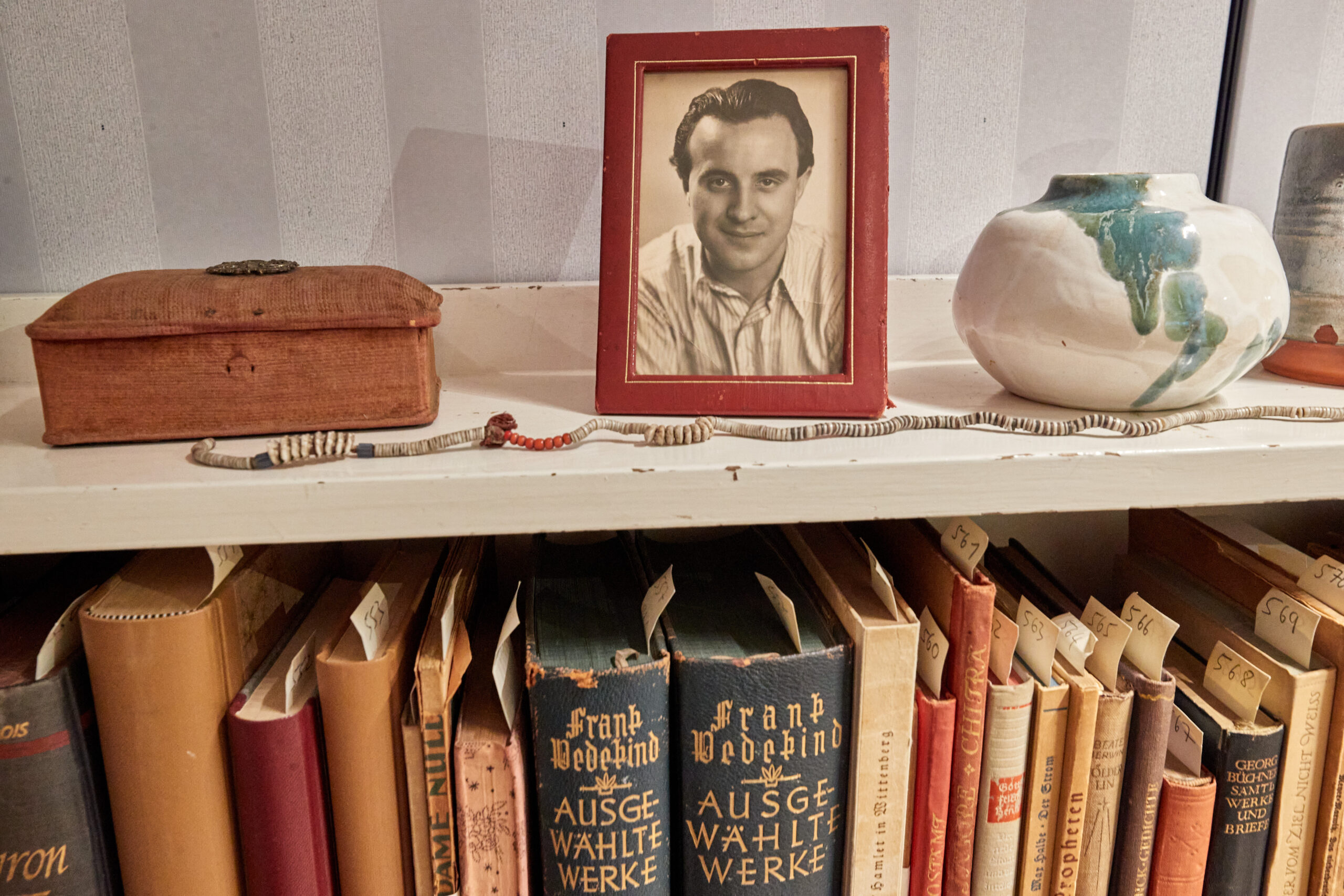 Ein Bilderrahmen mit einer Fotografie des Schriftstellers Wolfgang Borchert steht auf einem Bücherregal in der „Borchert-Box“ der Universitätsbibliothek Hamburg.