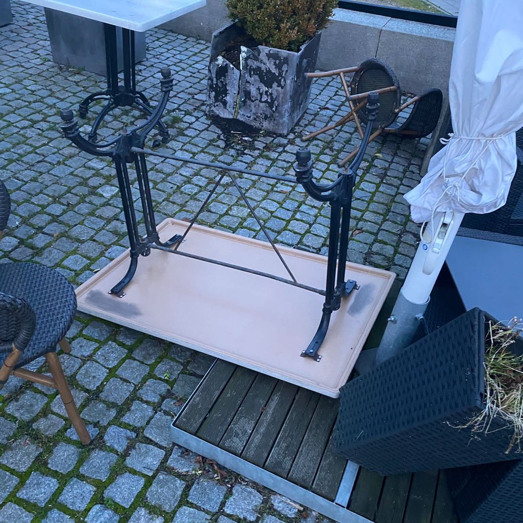 Ein kaputter Pflanzenkübel, umgestoßene Tische und Stühle