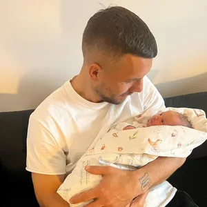 Lukas Podolski hält Tochter Ella im Arm.
