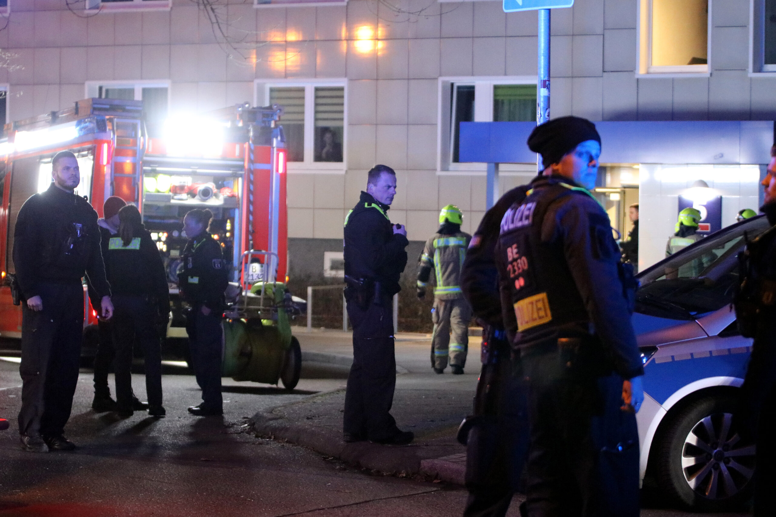 Einsatzkräfte von Polizei und Feuerwehr arbeiten am Tatort im Berliner Stadtteil Lichtenberg.