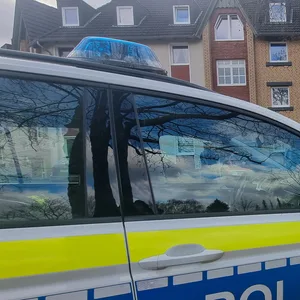 Ein Polizeiauto steht im Zuge von Ermittlungen vor einem Mehrfamilienhaus in Barsinghausen.
