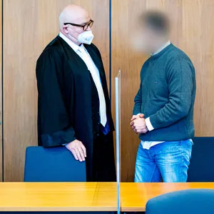 Der Angeklagte (r.) steht neben seinem Verteidiger in einem Saal des Landgerichts Hildesheim.