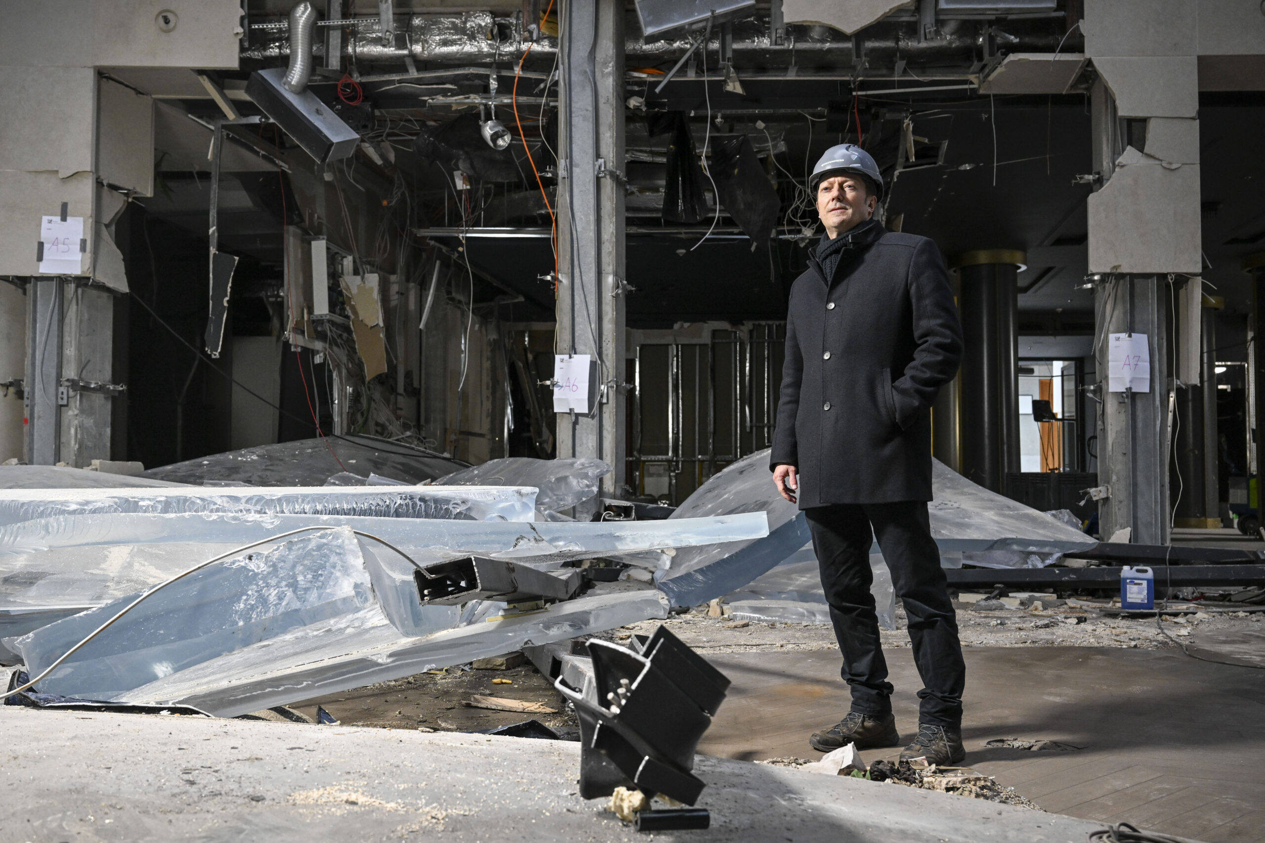 Fabian Hellbusch, Leiter Marketing und Kommunikation bei Union Investment Real Estate GmbH, steht nach dem Platzen des Großaquariums am zerstörten Zylinder des Aquadoms und Resten der Acrylverkleidung.