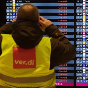 Ein Mann mit Verdi-Weste fotografiert während eines Warnstreiks am Flughafen Berlin-Brandenburg BER eine Anzeigetafel, auf der alle Flüge als gestrichen angezeigt werden. Die Gewerkschaft Verdi hat zu einem ganztägigen Warnstreik am Flughafen Berlin-Brandenburg aufgerufen.