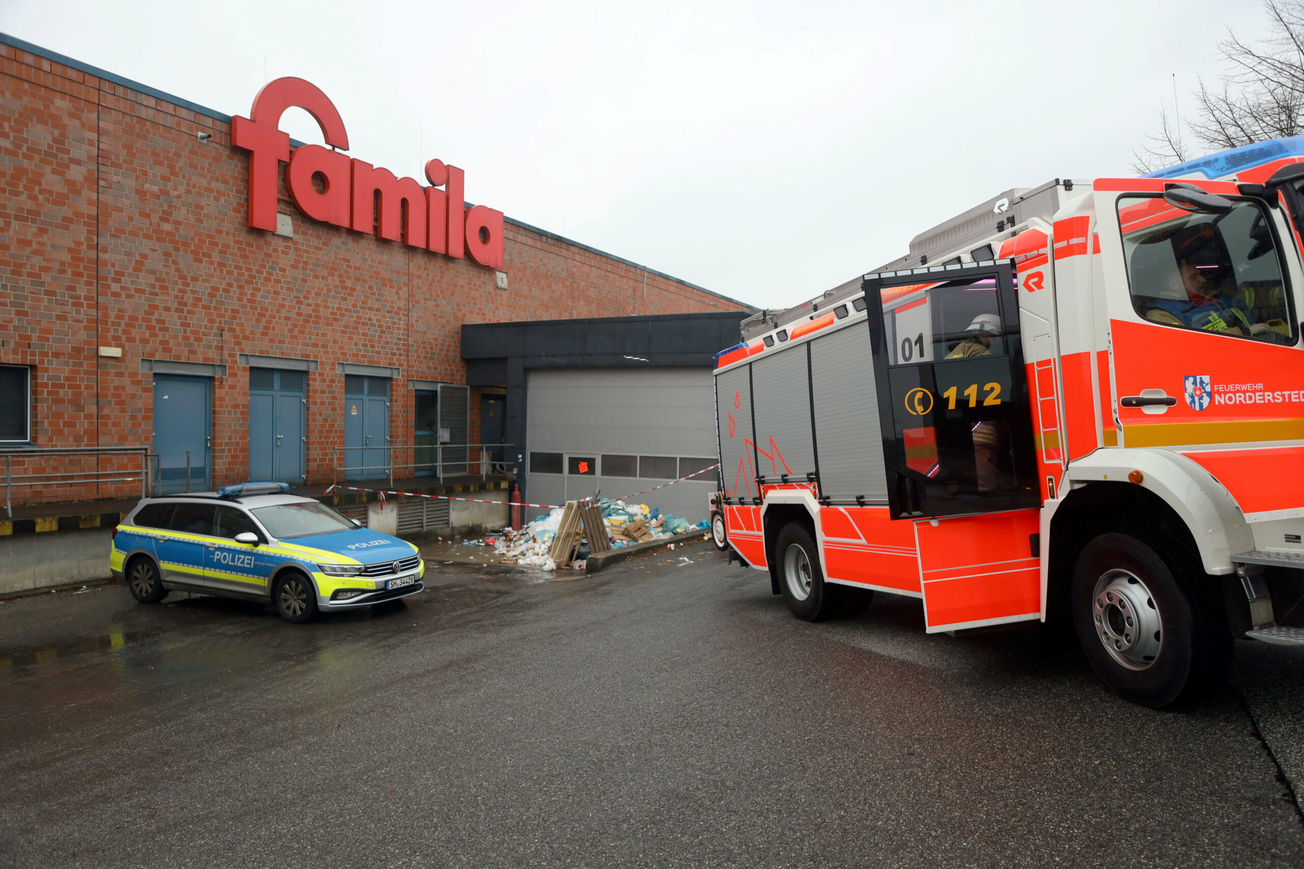 Feuerwehr und Polizei sind vor der Müllpresse einer „famila“-Filiale in Norderstedt im Einsatz.