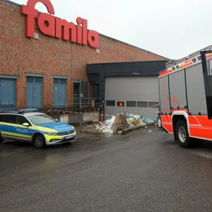 Feuerwehr und Polizei sind vor der Müllpresse einer „famila“-Filiale in Norderstedt im Einsatz.