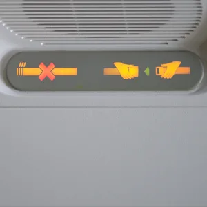 Leuchtanzeige im Flugzeug, die auf Rauchverbot und Anschnallpflicht hinweist.