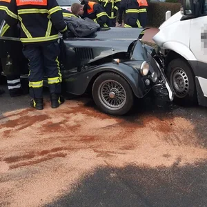 Die Feuerwehr kümmert sich an der Unfallstelle in Jork um den zerstörten Oldtimer.