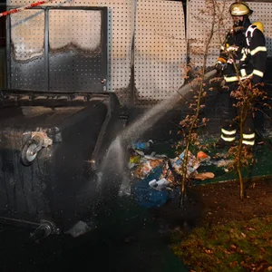 Feuerwehrleute vor gelöschtem Müllcontainer