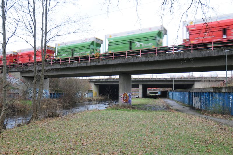 Ein Güterzug vor dem Tunneleingang an der Seevetalstraße, links fließt die Seeve.