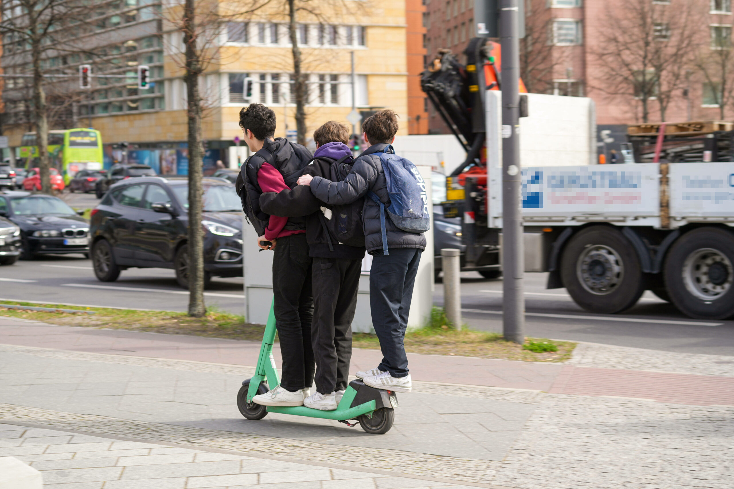 Drei Kinder auf einem E-Scooter