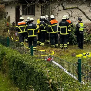 Feuerwehr- und Polizeikräfte vor dem Einfamilienhaus.