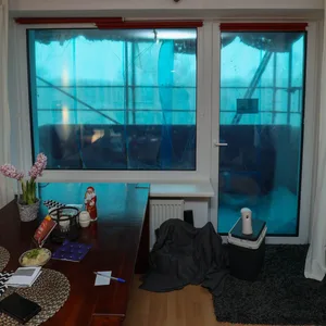 Das Wohnzimmer von Frau Kerl ist dunkel, und sie kaum aus dem Fenster blicken, weil eine Plane davor hängt.