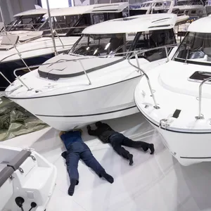 Messebauer arbeiten bei Aufbauarbeiten für die Hamburg Boat Show zwischen kleinen Motorjachten. (Symbolbild)