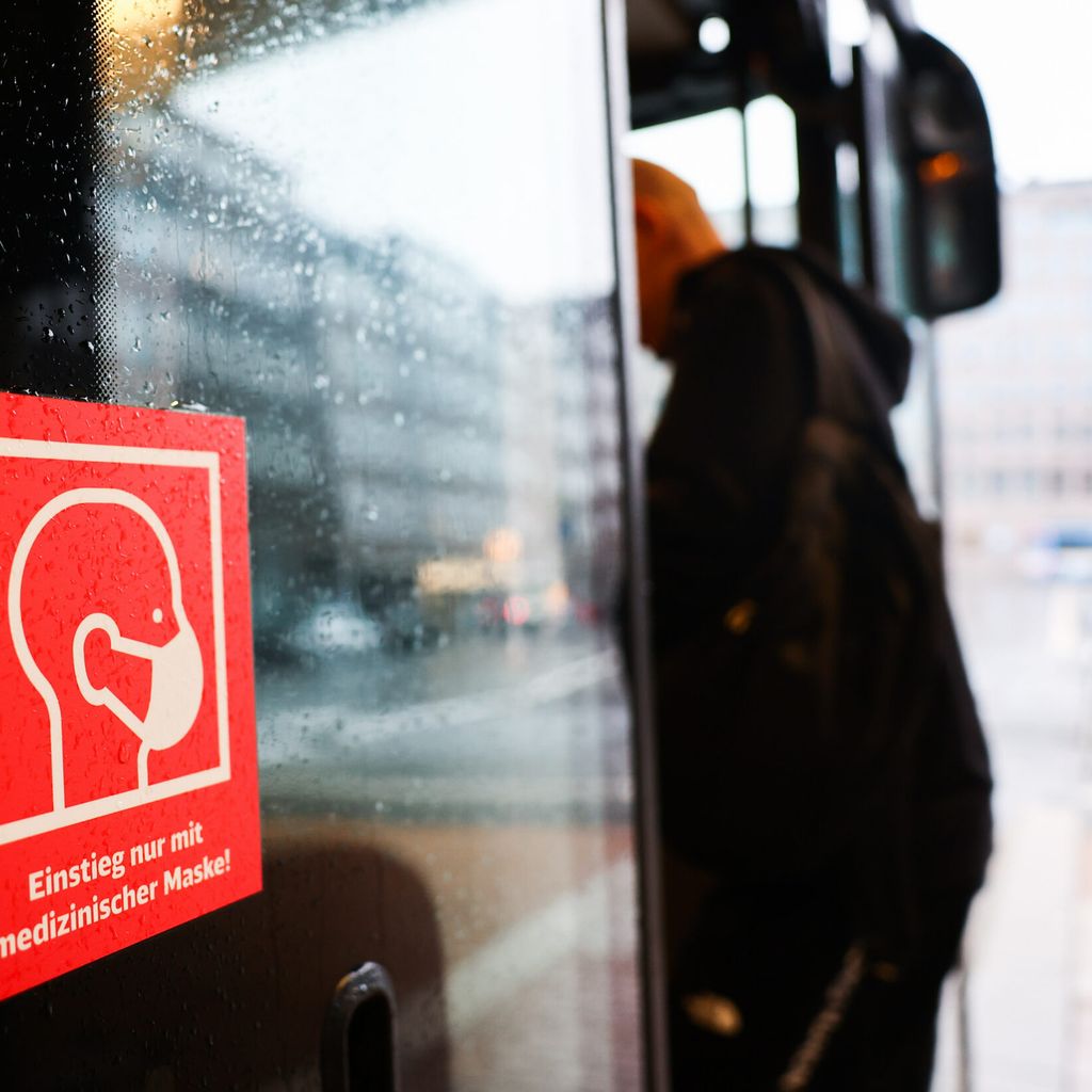 Ein Aufkleber an der Tür eines Linienbusses verweist auf das tragen einer medizinischen Maske.