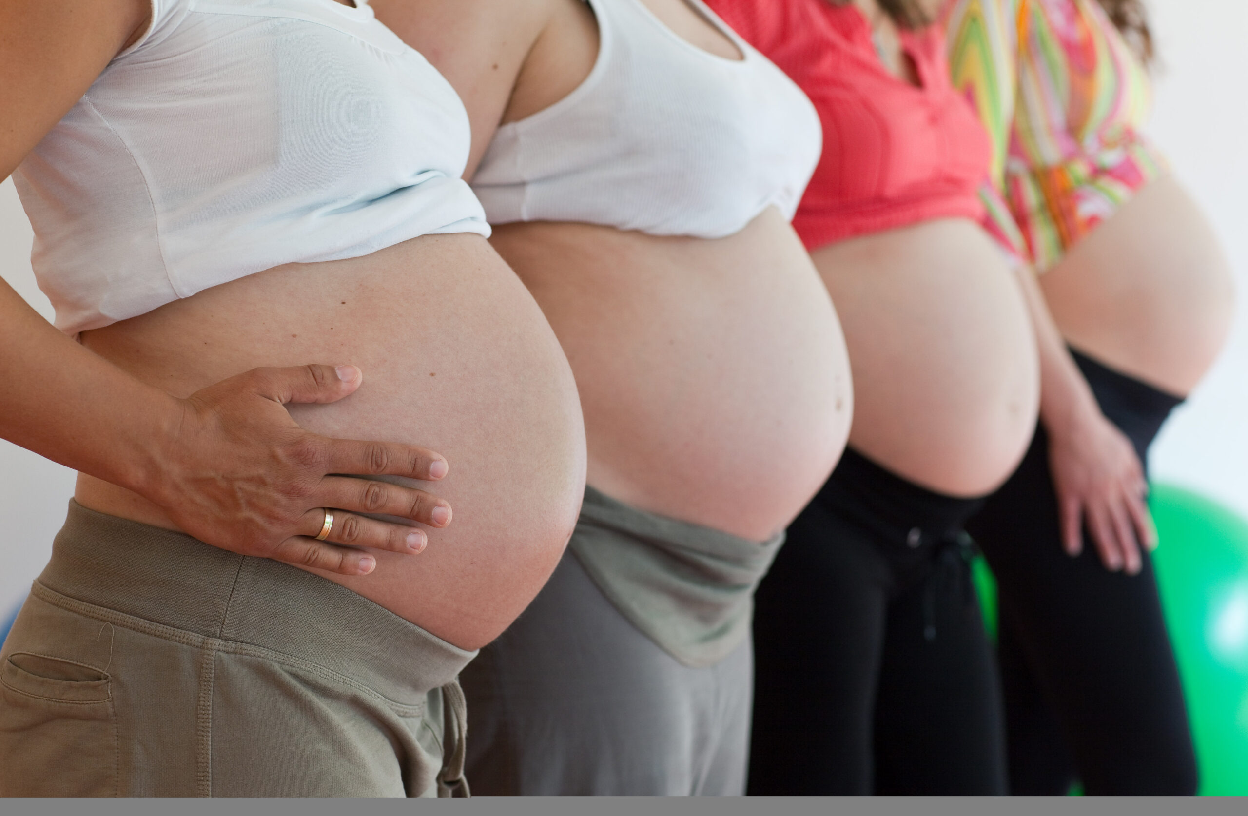 Schwangere Frauen zeigen ihre Bäuche.