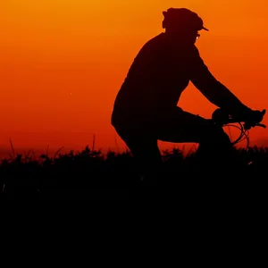 Ein Radfahrer ist am Morgen kurz vor Sonnenaufgang mit seinem Fahrrad unterwegs.