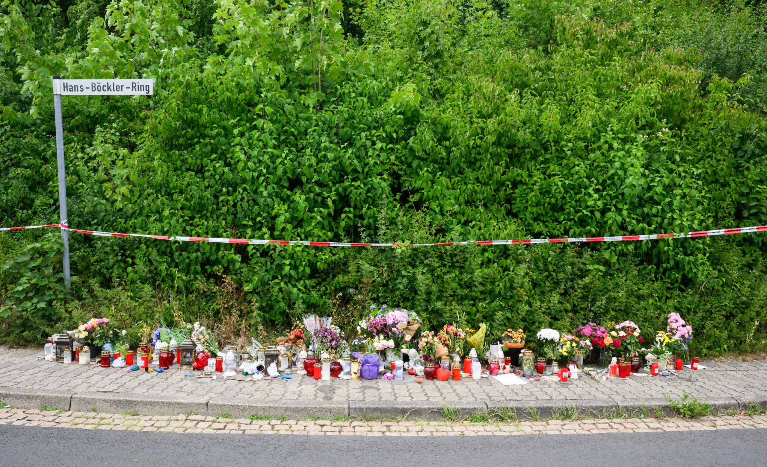 Blumen und Kerzen stehen in der Nähe des Tatorts, an dem die 15-jährige Anastasia getötet wurde.