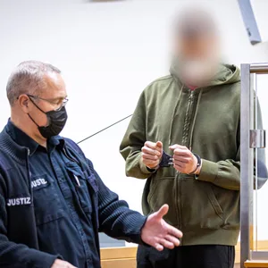 Der Angeklagte wird in Handschellen ins Gericht geführt