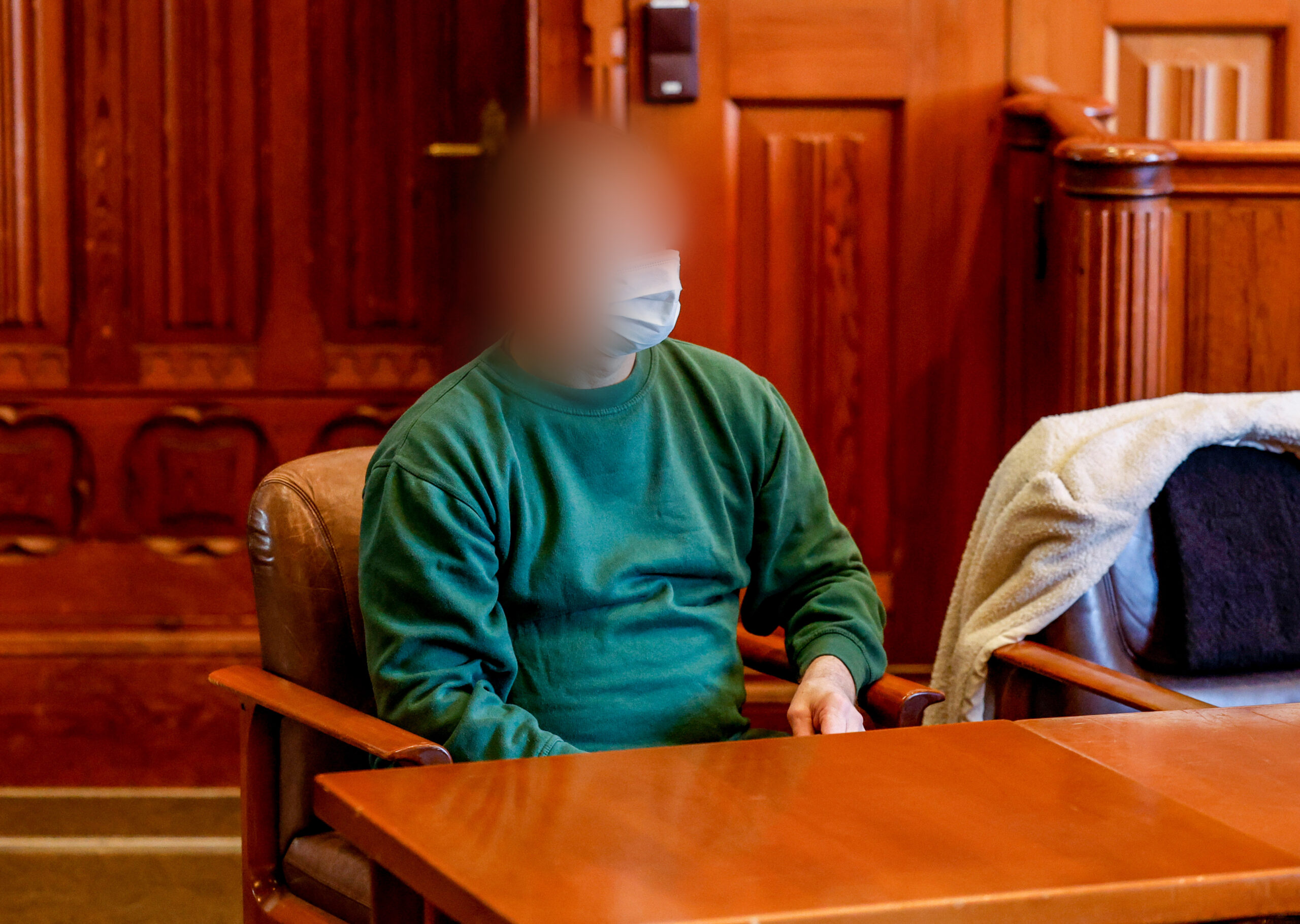 Der Vater, der 2016 auf Sylt sein Baby getötet haben soll, wartet im Gerichtssaal auf den Beginn der Verhandlung.