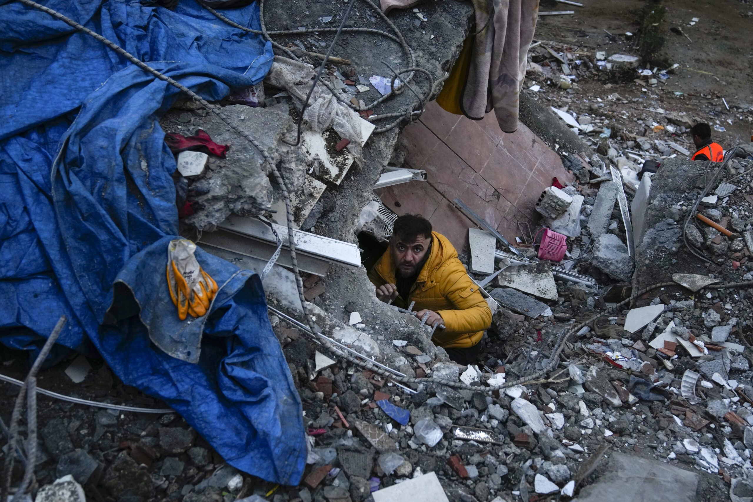 Ein Mann sucht nach Menschen in den Trümmern eines zerstörten Gebäudes.