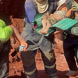 Nach einer nächtlichen Rettungsaktion tragen Rettungskräfte und Militärs ein einjähriges Kind aus einem tiefen Loch in der nordthailändischen Provinz Tak