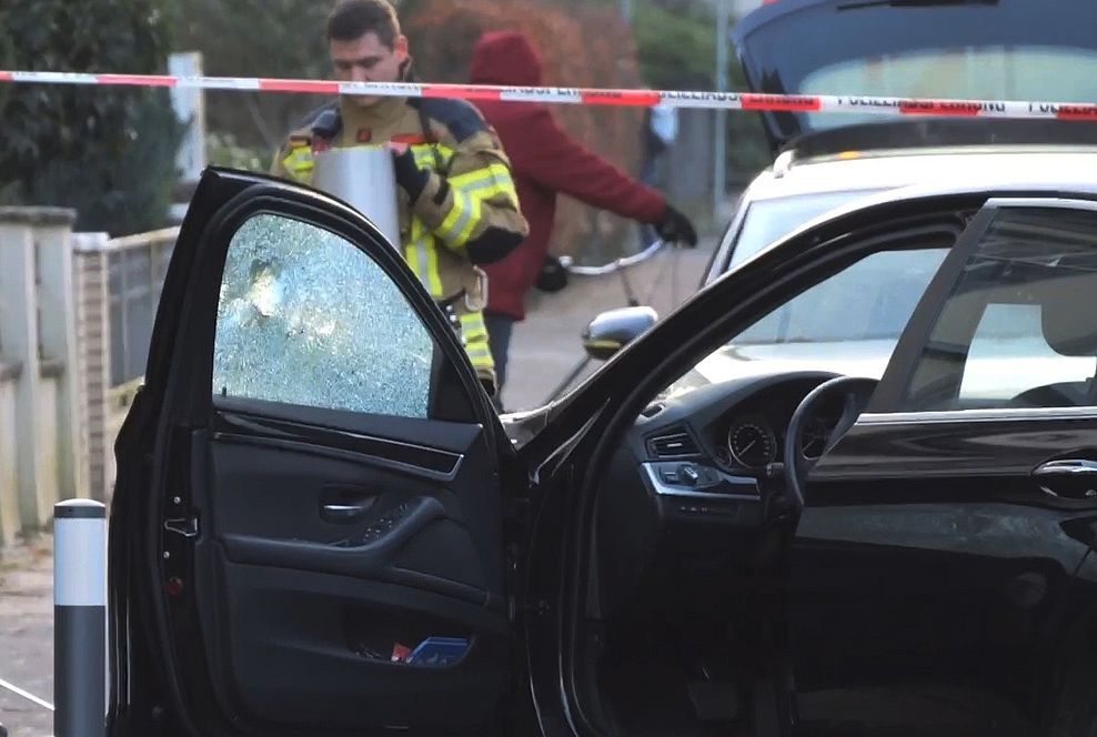 Ein PKW, an dem die Beifahrer-Scheibe ein Loch hat, wird untersucht