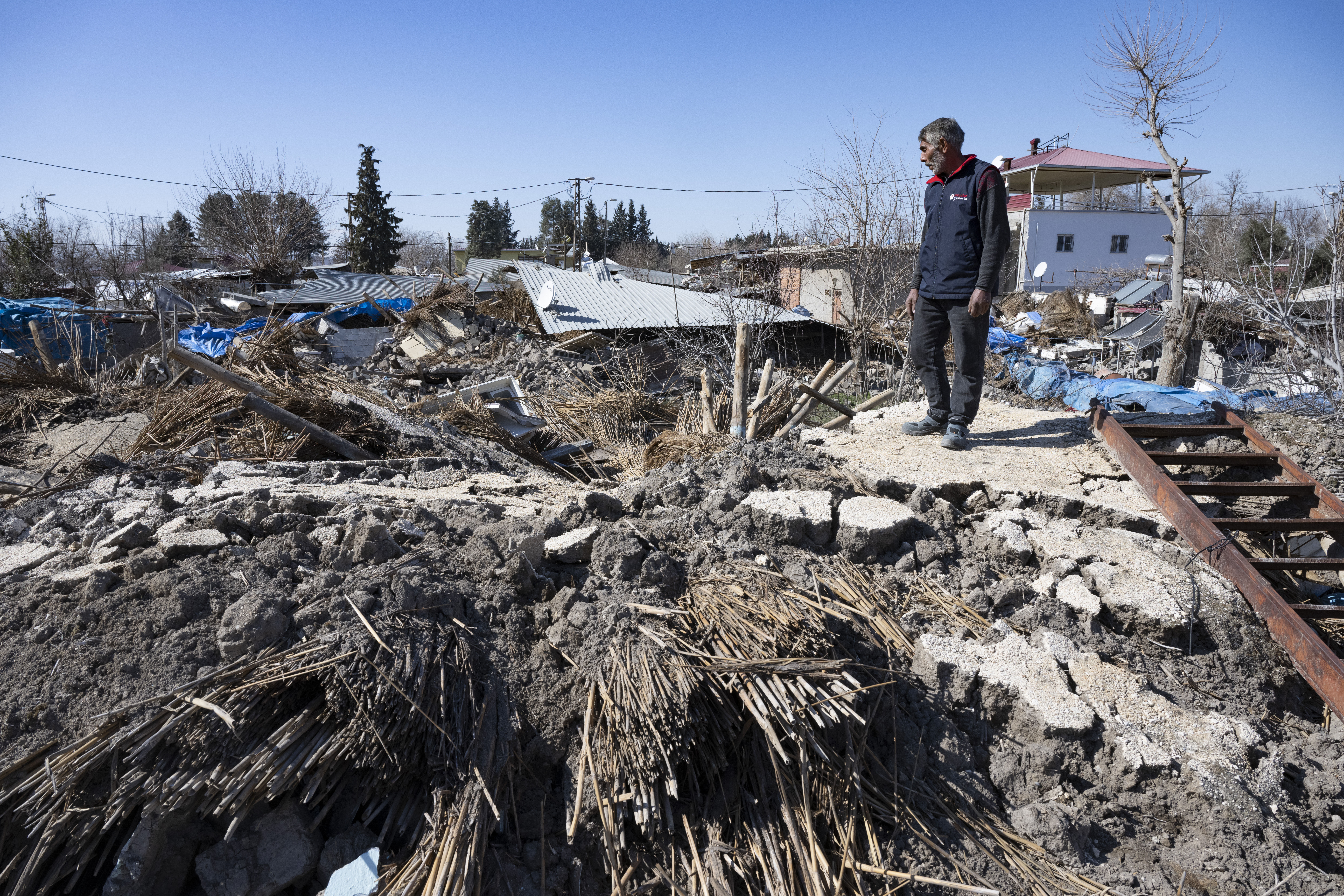Ein Dorfbewohner blickt auf die Trümmer seines eingestürzten Hauses.