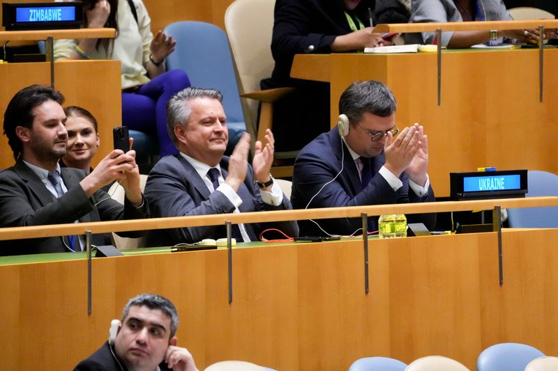 Dmytro Kuleba (r), Außenminister der Ukraine, und Serhij Kyslyzja (M), Ständiger Vertreter der Ukraine bei den Vereinten Nationen, applaudieren während die Generalversammlung der Vereinten Nationen für eine Resolution stimmt.